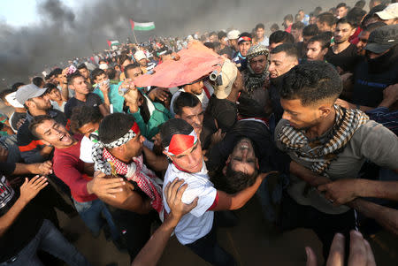 A wounded Palestinian is evacuated during a protest calling for lifting the Israeli blockade on Gaza and demanding the right to return to their homeland, at the Israel-Gaza border fence in the southern Gaza Strip October 19, 2018. REUTERS/Ibraheem Abu Mustafa