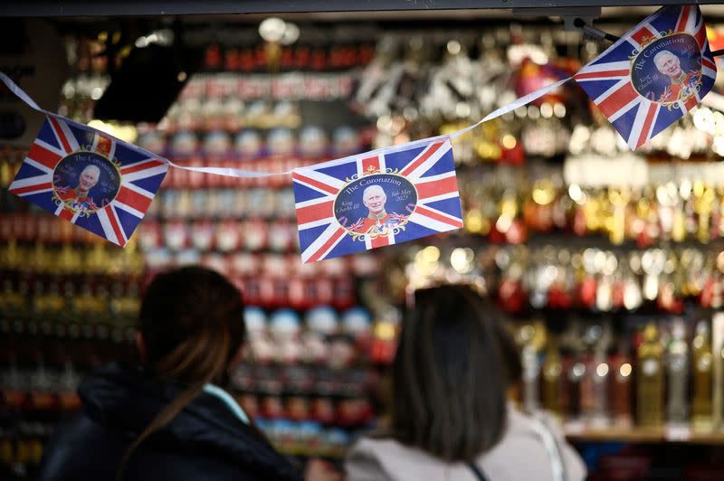 FILE PHOTO: People browse a souvenir kiosk that is displaying items designed for the Coronation of King Charles III in London