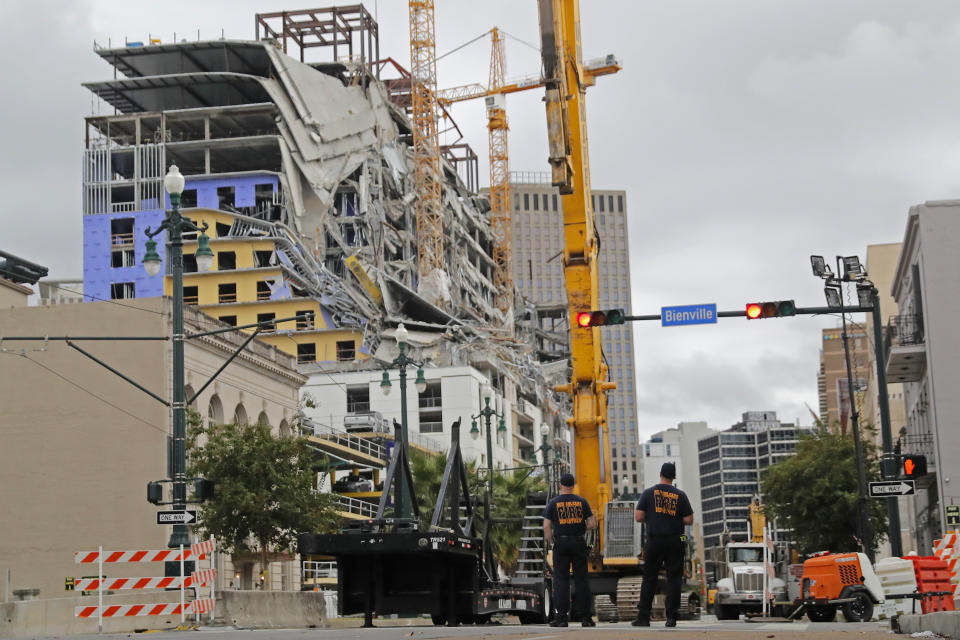 New Orleans Fire Department personnel stand by the scene of the Hard Rock Hotel in New Orleans, Wednesday, Oct. 16, 2019. New Orleans officials say the chances of a missing worker's survival after the collapse are diminishing, and they have shifted their efforts from rescue to recovery mode. News outlets report Fire Department Superintendent Tim McConnell says they shifted Wednesday ahead of a possible tropical storm. McConnell says chances of the missing worker's survival will be considered nearly "zero" if no sign of him turns up by Wednesday night. (AP Photo/Gerald Herbert)