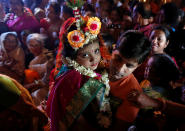 <p>Soumili Mukherjee, a five-year old girl dressed as a Kumari, who is worshipped as part of the Durga Puja rituals, is carried by her father to a temporary platform called pandal, during the Hindu religious festival Durga Puja in Kolkata, India, Sept. 28, 2017. (Photo: Rupak De Chowdhuri/Reuters) </p>