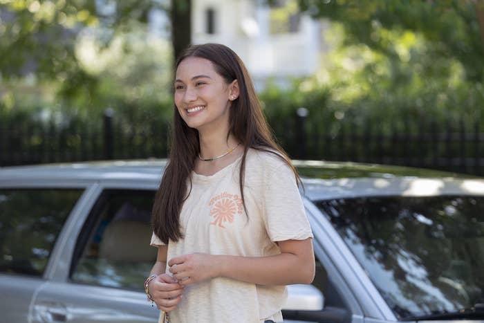 Belly standing near a car and wearing a T-shirt and smiling