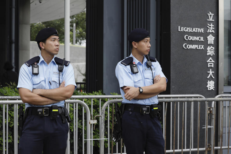 Police stand guard at fencing surrounding the Legislative Council to help block protesters during upcoming meetings on the government's extradition law bill, in Hong Kong, Tuesday, June 11, 2019. Local media reports said police were mobilizing thousands of additional officers to keep order amid calls for protesters to begin gathering Tuesday night. Some businesses have also announced plans to close on Wednesday and scattered reports told of students planning to boycott classes. (AP Photo/Vincent Yu)