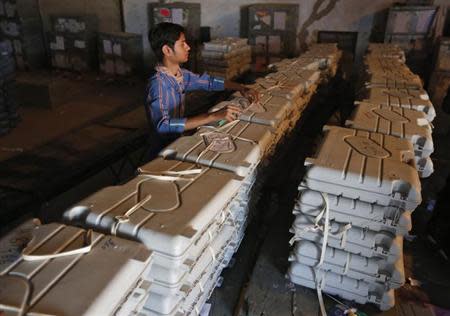 A member of election duty staff arranges electronic voting machines (EVM) inside a strong room ahead of the 2014 general elections in Ahmedabad March 21, 2014. REUTERS/Amit Dave