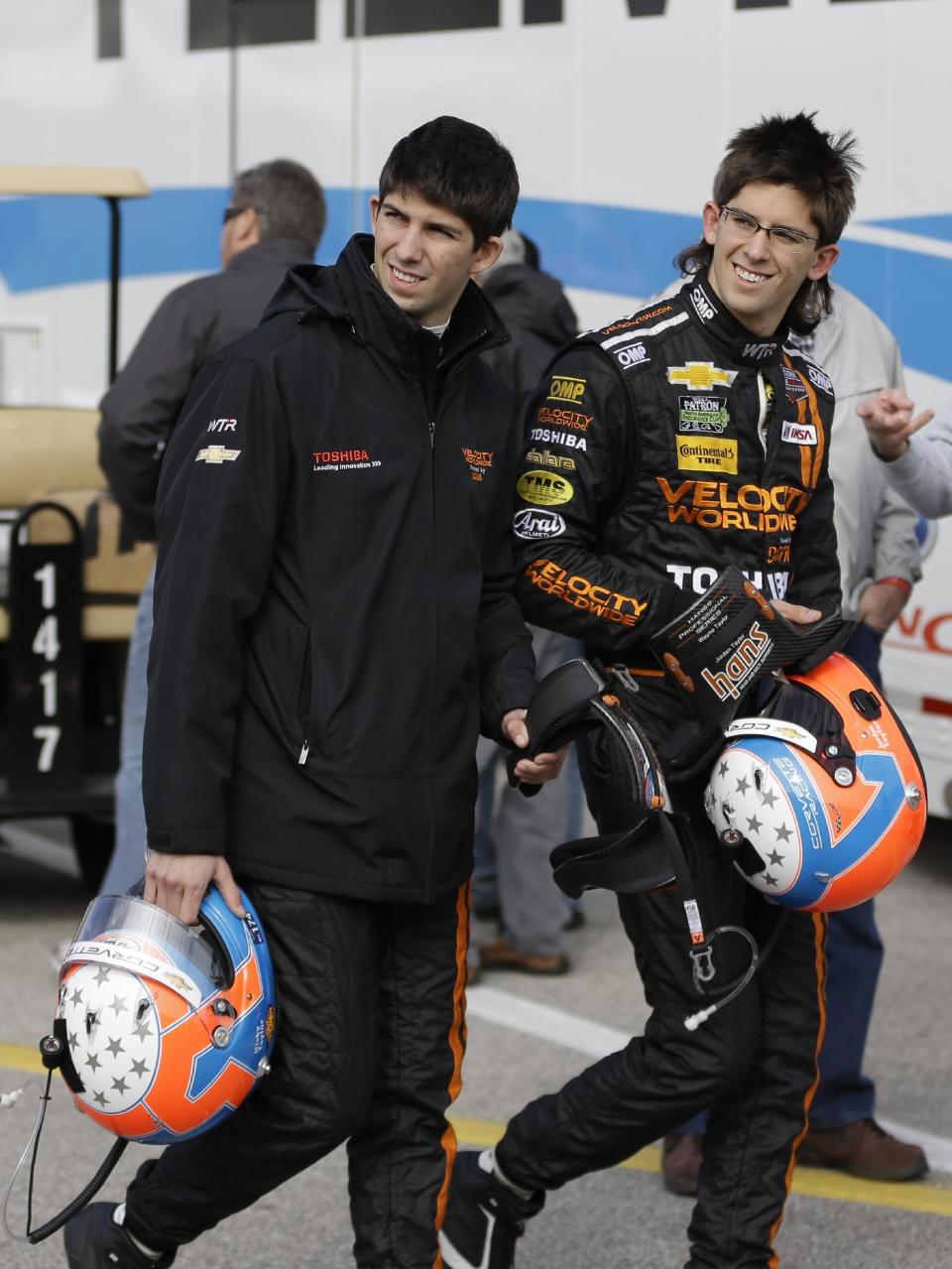 Brothers Ricky Taylor, left, and Jordan Taylor walk through the garage area after a practice session for the IMSA Series Rolex 24 hour auto race at Daytona International Speedway in Daytona Beach, Fla., Thursday, Jan. 23, 2014.(AP Photo/John Raoux)