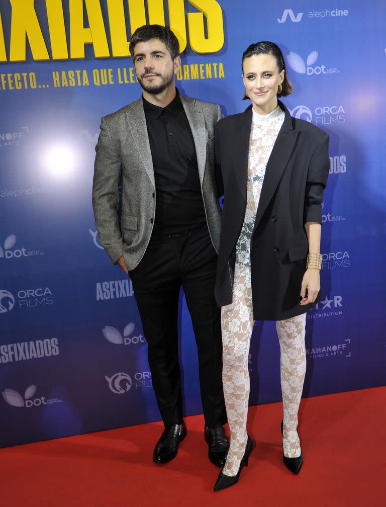 Marco Antonio Caponi y la actriz Mónica Antonópulos fueron una de las parejas más elegantes de la noche. Mientras que el actor se sumó a la tendencia del traje con remera, la actriz deslumbró con un mono de encaje blanco que dejaba ver su ropa interior en negro. El blazer XL fue perfecto para insinuar sin mostrar tanto 