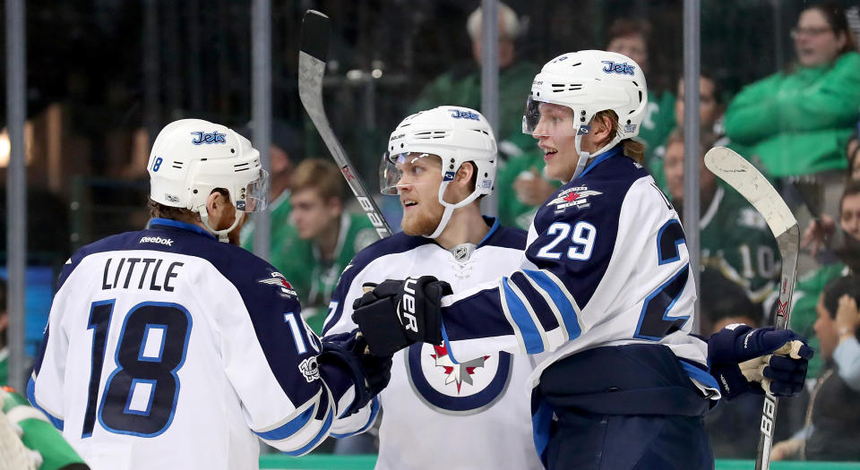 Winnipeg's Nikolaj Ehlers (#27) celebrates with Patrik Laine (#29) and Bryan Little (#18) after scoring against the Dallas Stars in February 2017. (Photo by Tom Pennington/Getty Images)