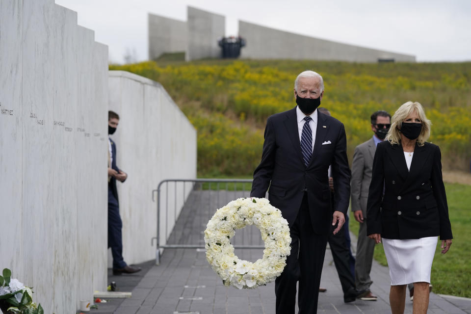 Democratic presidential candidate and former Vice President Joe Biden carries a wreath as he walks with his wife Jill Biden during a visit to the Flight 93 National Memorial in Shanksville, Pa., Friday, Sept. 11, 2020, to commemorate the 19th anniversary of the Sept. 11 terrorist attacks. (AP Photo/Patrick Semansky)