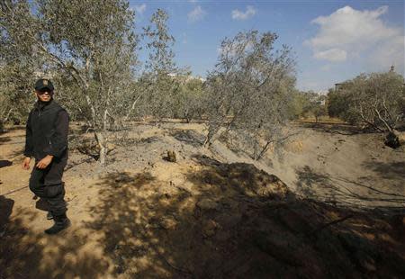 A Palestinian policeman loyal to Hamas inspects the scene of an Israeli air strike in the northern Gaza Strip October 28, 2013. REUTERS/Suhaib Salem