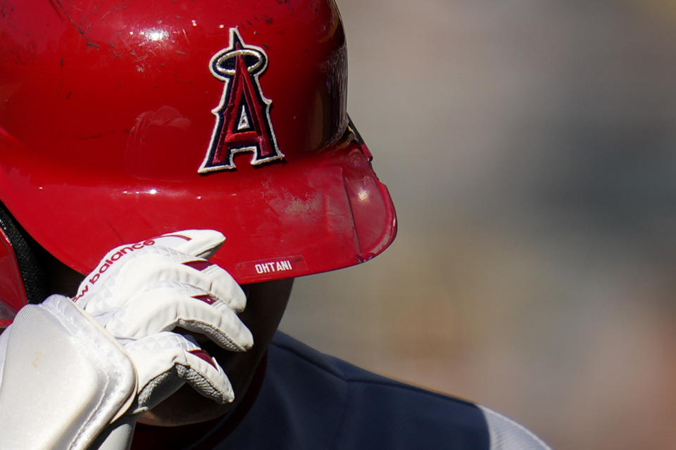 Los Angeles Angels' Shohei Ohtani touches his helmet as he walks back to the dugout after grounding out during the first inning of a baseball game against the San Diego Padres, Wednesday, July 5, 2023, in San Diego. (AP Photo/Gregory Bull)
