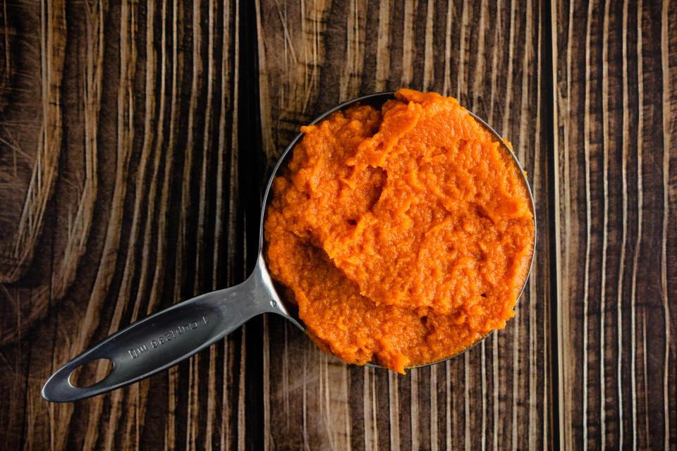 A measuring cup of canned pumpkin.