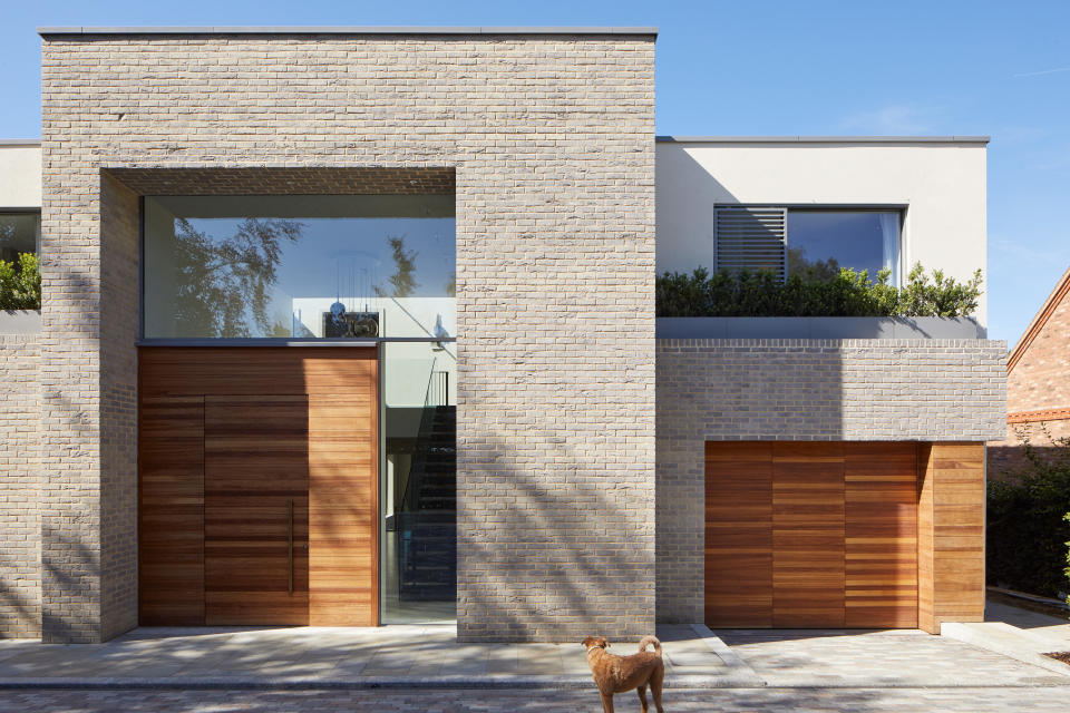 Frontage of modern home with wooden door and garage