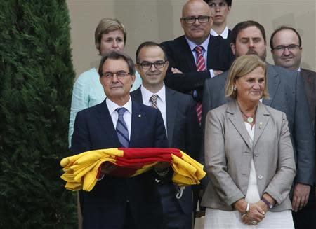 Catalonia's regional president Artur Mas (L) holds a regional flag surrounded by local politicians during ceremony to mark the "Diada de Catalunya" (Catalunya's National day) in central Barcelona September 11, 2013. REUTERS/Gustau Nacarino