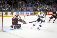 Elvis Merzlikins of Latvia, left, and Saku M'enalanen of Finland in action during the 2022 IIHF Ice Hockey World Championships preliminary round group B match between Latvia and Finland in Tampere, Finland, Saturday, May 14, 2022. (Emmi Korhonen/Lehtikuva via AP)