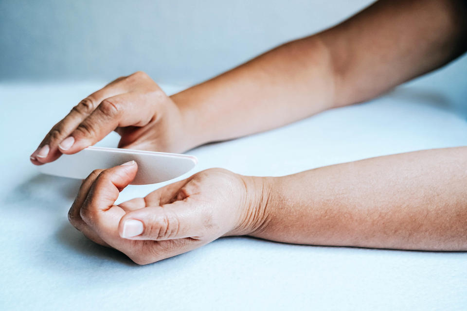 Woman hands doing manicure at home (violet photo / Getty Images stock)