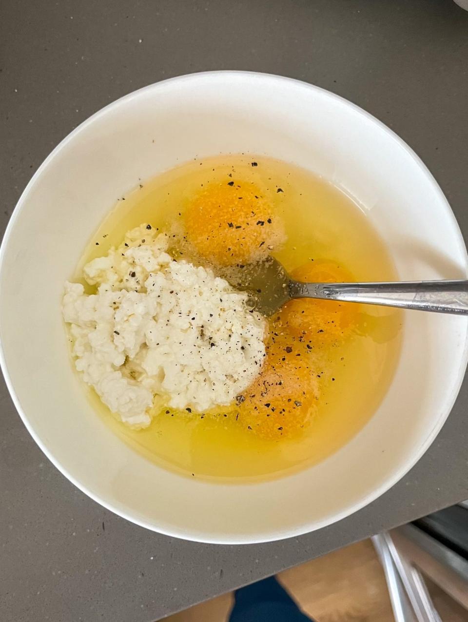 Eggs, cottage cheese, salt, and pepper in a bowl