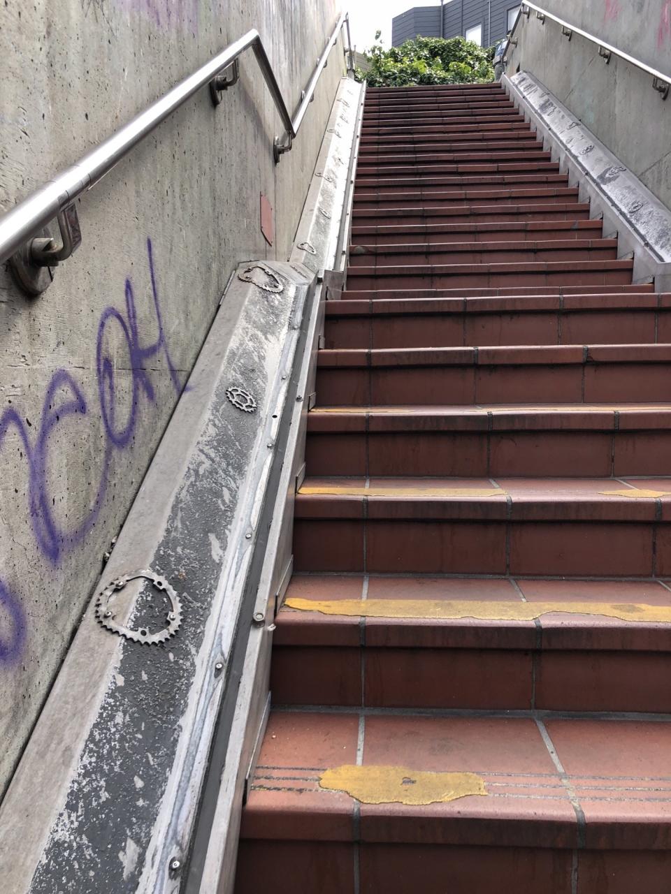 A groove for bikes on the side of a staircase