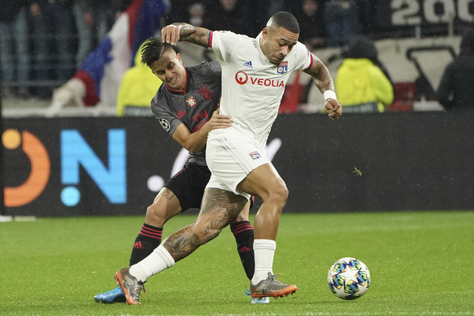 Lyon's Memphis Depay, right, vies for the ball with Benfica's Franco Cervi during the group G Champions League soccer match between Lyon and Benfica at the Lyon Olympic Stadium in Decines, outside Lyon, France, Tuesday, Nov. 5, 2019. (AP Photo/Laurent Cipriani)