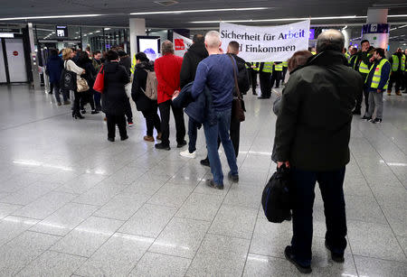 Airport employees queue in front of an internal security check as passengers security check points are closed during a strike over higher wages at Germany's largest airport in Frankfurt, Germany, January 15, 2019. REUTERS/Kai Pfaffenbach