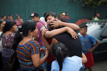 Relatives of missing garbage collectors react as they wait for news of their loved ones outside a landfill dumpsite, where a massive pile of garbage collapsed and buried several people, in Guatemala City, Guatemala, April 28, 2016. REUTERS/Saul Martinez