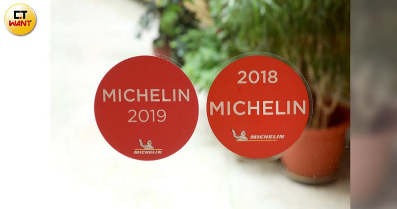 上林鐵板燒入口透明門上有兩張紅色圓貼紙─2018及2019的「米其林餐盤推薦」。（圖／王永泰攝）