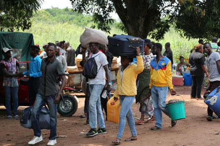 Congolese migrants cross carry their belongings as they cross from Angola at the Kamako border, Kasai province in the Democratic Republic of the Congo, October 13, 2018. REUTERS/Giulia Paravicini