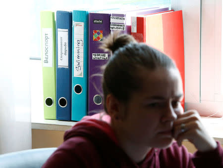 Folders reading "Cycling", "Wrestling", "Swimming", "Weightlifting", "Triathlon", "Water Polo", are seen behind an employee at the Russian Anti-Doping Agency (RUSADA) in Moscow, Russia, May 24, 2016. REUTERS/Sergei Karpukhin