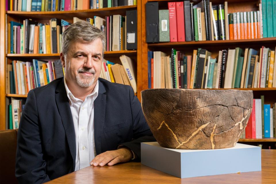 George Aaron Broadwell, a University of Florida linguist who has compiled a dictionary of the Timucua language, poses with a reconstructed Timucua bowl.