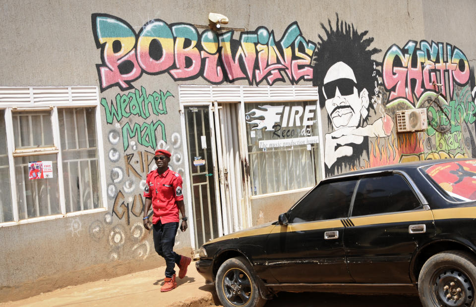 A musician and supporter of pop star-turned-opposition lawmaker Bobi Wine, whose real name is Kyagulanyi Ssentamu, walks past Wine's recording studio in the Kamwokya neighborhood where he has many supporters, in Kampala, Uganda Thursday, Sept. 20, 2018. Security forces took Bobi Wine into custody when he arrived from the United States on Thursday, angering his supporters, while authorities barred public gatherings. (AP Photo/Ronald Kabuubi)