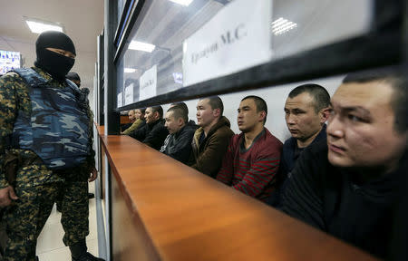 Islamic State supporters, who attacked a National Guard facility in June, sit inside a glass-walled cage during a verdict hearing at a court in Aktobe, Kazakhstan, November 28, 2016. REUTERS/Stringer