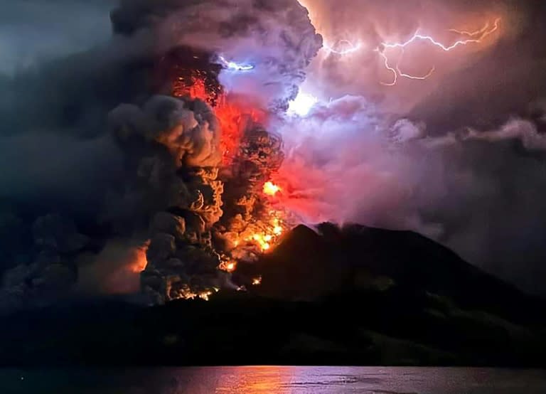 This handout photograph taken and released by the Center for Volcanology and Geological Hazard Mitigation on April 17, 2024, shows Mount Ruang spewing hot lava and smoke (Handout)