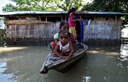 Villagers use a boat as they try to move to safer places at a flood-affected village in Darrang district in the northeastern state of Assam. REUTERS/Anuwar Hazarika