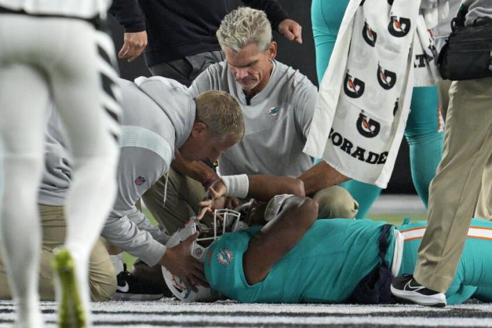 Tua Tagovailoa, quarterback de los Dolphins de Miami, recibe atención tras golpearse la cabeza y el cuello durante el partido del jueves 29 de septiembre de 2022, ante los Bengals de Cincinnati (AP Foto/Jeff Dean)