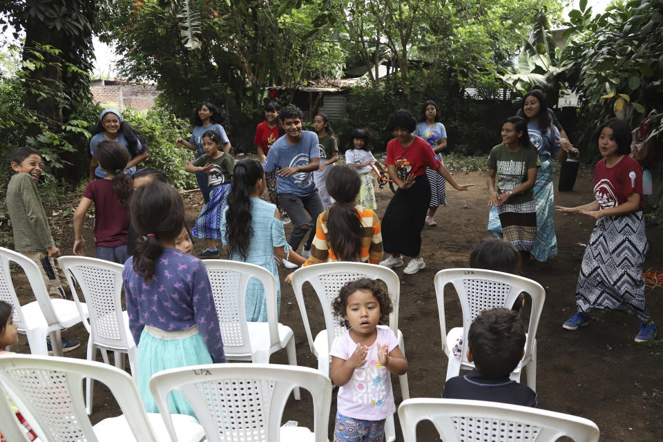 Assemblies of God Church members sing praises and dance during a day of Bible teaching for children, in a community once controlled by gangs in Santa Ana, El Salvador, Saturday, April 29, 2023. (AP Photo/Salvador Melendez)