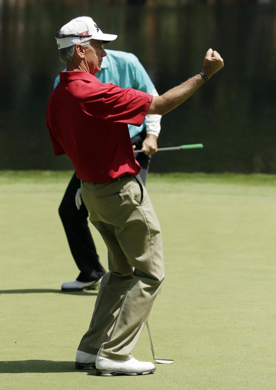 Larry Mize pumps his fist after a birdie on the ninth hole during the par three competition at the Masters golf tournament Wednesday, April 9, 2014, in Augusta, Ga. (AP Photo/Chris Carlson)