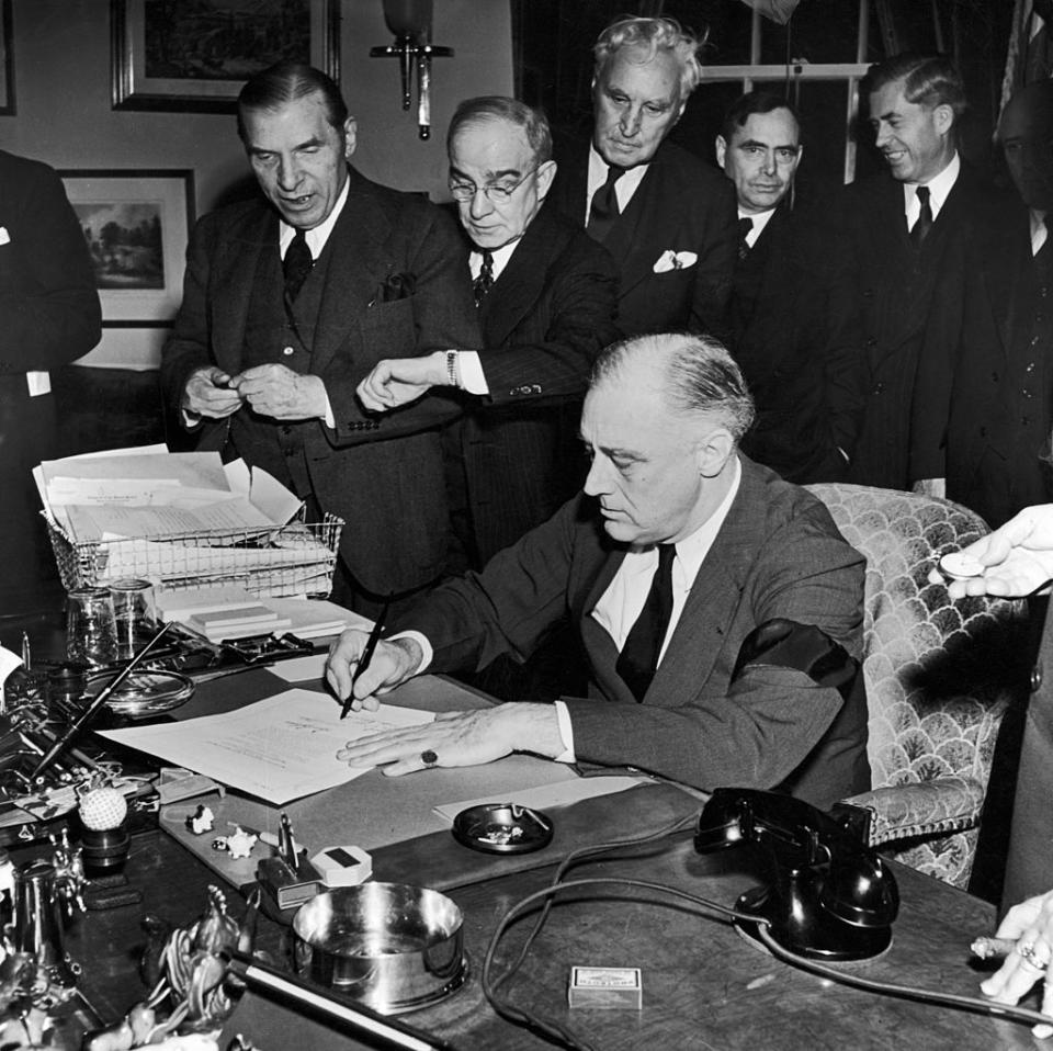 President Franklin D. Roosevelt (wearing black armband) signing declaration of war as others look on, following Japanese bombing of Pearl Harbor.<span class="copyright">Thomas D. Mcavoy/The LIFE Picture Collection—Getty Images</span>