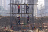 Workers construct a steel structure as they build a column at a flyover construction site at Xiongan in northern China's Hebei province on March 14, 2024. China’s first generation of migrant workers played an integral role in the country's transformation from an impoverished nation to an economic powerhouse. Now, they're finding it hard to find work, both because they're older and the economy is slowing. (AP Photo/Tatan Syuflana)