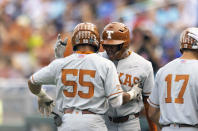 Texas' Cam Williams (55), left, celebrates with Trey Faltine, center, after hitting a two-run home run in the second inning against Mississippi State during a baseball game in the College World Series Saturday, June 26, 2021, at TD Ameritrade Park in Omaha, Neb. (AP Photo/Rebecca S. Gratz)