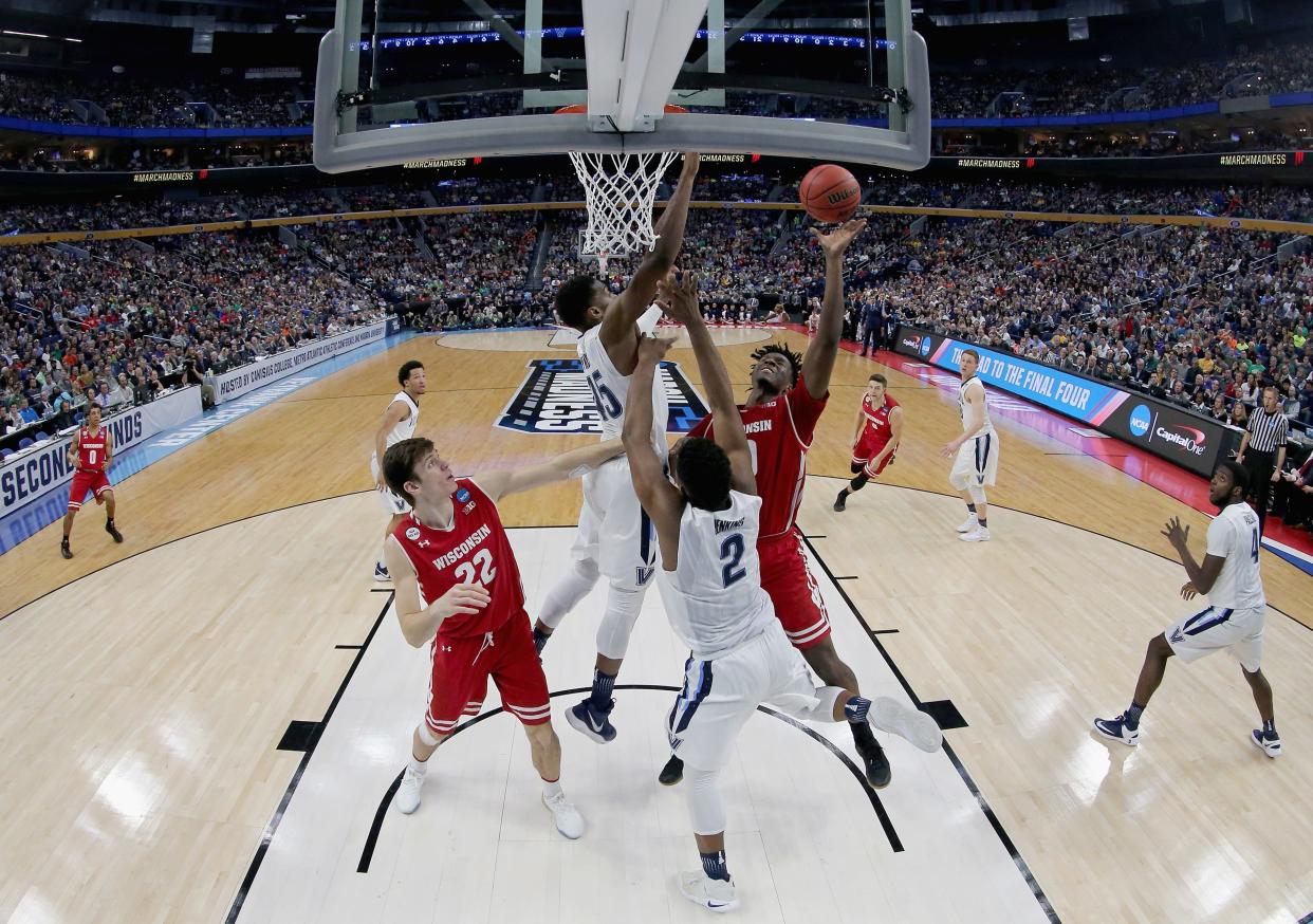 Nigel Hayes  drives to the basket while being defended by Villanova's Kris Jenkins in the second round of the 2017 NCAA tournament.