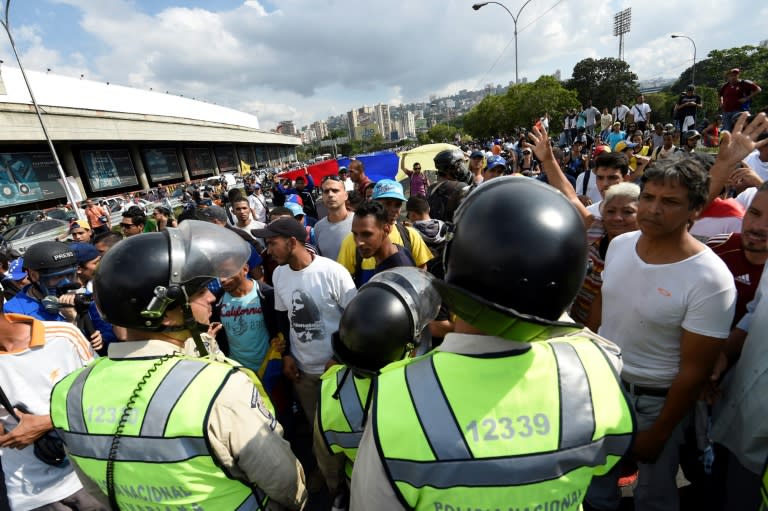 National police officers prevent demonstrators protesting against the government of Venezuelan President Nicolas Maduro in eastern Caracas from heading to the capital's downtown