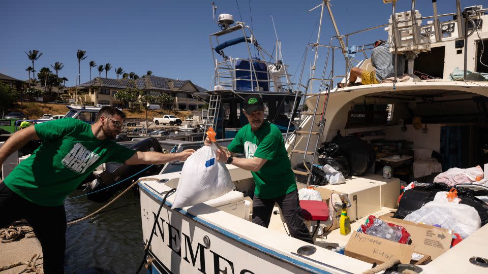 Volunteers in Maalaea, Hawaii, on August 12, 2023, load a boat with supplies to deliver to West Maui towns affected by wildfires.  - Yuri Iwamura/AFP/Getty Images