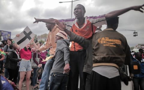 People cheer during a during a march in the streets to demand that President Robert Mugabe resign and step down from power in Harare, Zimbabwe, on November 19, 2017 - Credit: Barcroft Media