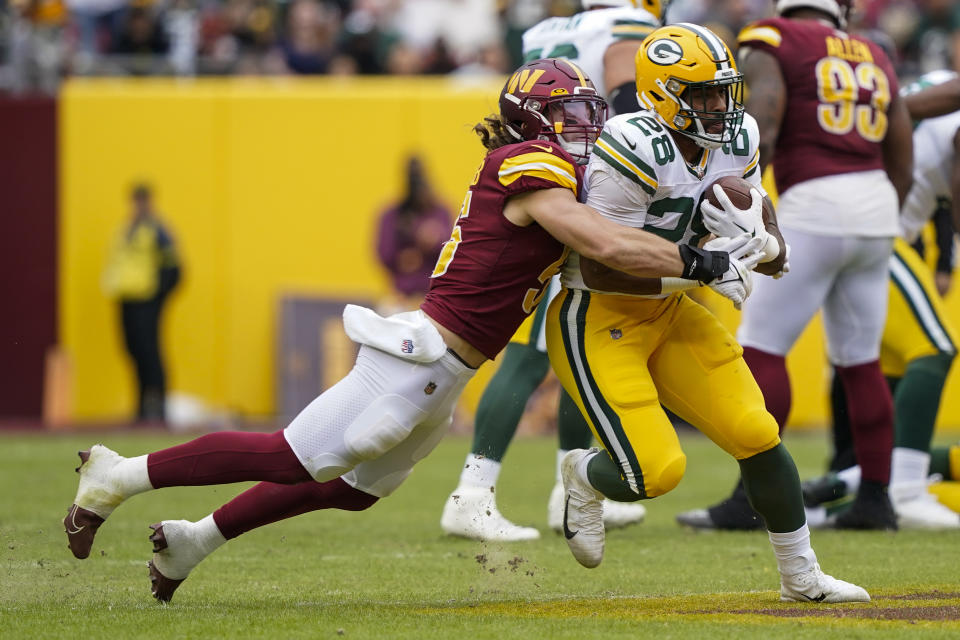Washington Commanders linebacker Cole Holcomb (55) tackles Green Bay Packers running back AJ Dillon (28) during the second half of an NFL football game Sunday, Oct. 23, 2022, in Landover, Md. (AP Photo/Susan Walsh)
