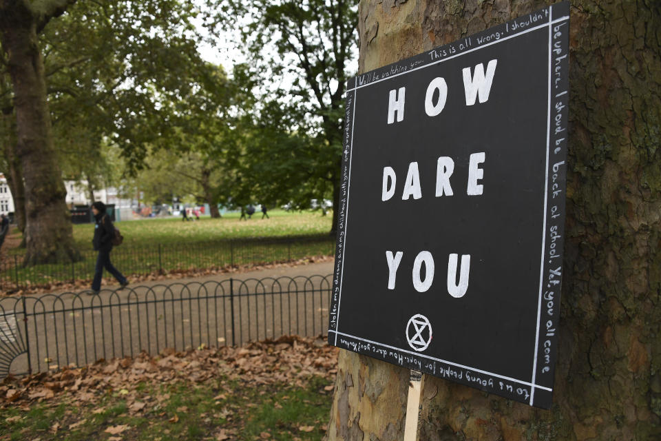 A banner leans up against a tree in London, Monday, Oct. 7, 2019. (Photo: Alberto Pezzali/AP)