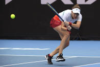 Belinda Bencic of Switzerland plays a backhand return to Kristina Mladenovic of France during their first round match at the Australian Open tennis championships in Melbourne, Australia, Monday, Jan. 17, 2022. (AP Photo/Andrew Brownbill)
