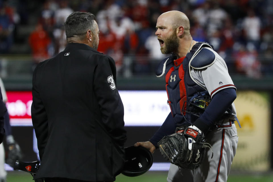 Atlanta Braves catcher Brian McCann, right, reacts to umpire Rob Drake after relief pitcher Shane Carle was ejected for hitting Philadelphia Phillies' Rhys Hoskins with a pitch during the seventh inning of a baseball game, Sunday, March 31, 2019, in Philadelphia. (AP Photo/Matt Slocum)