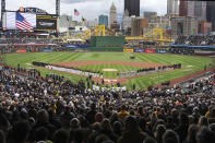 The Pittsburgh Pirates line the third baseline with the Baltimore Orioles along the first baseline during the national anthem before the Pirates's home opener baseball game in Pittsburgh, Friday, April 5, 2024. (AP Photo/Gene J. Puskar)