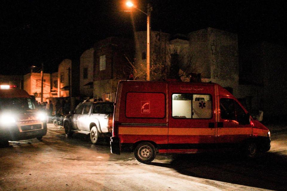 CAPTION CORRECTS THE FACT THAT NOBODY WAS KILLED IN THE OPERATION Emergency services outside the house of Ahmed Melk, a wanted militant, in Bourj Louzir, outside Tunis, Sunday, Feb. 9, 2014. Tunisia's government says the suspect in the July 25 assassination of an opposition politician is among four men arrested in an overnight counterterrorism raid. The Interior Ministry statement Sunday described the men as "dangerous terrorists" and identified one as Ahmed Melki, known as the "Somali" who is wanted in connected with the assassination of Mohammed Brahmi, a left-wing parliamentarian whose slaying last summer provoked a political crisis. (AP Photo/Aimen Zine)