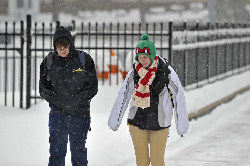 Penn State University students Dylan Reap, left, and Kasey Morgan walk to class along Fraser Street, Tuesday, Feb. 18, 2014, in State College, Pa. Snow closed all schools in Centre County but Penn State University remains open. (AP Photo/Centre Daily Times, Nabil K. Mark) MANDATORY CREDIT; MAGS OUT.