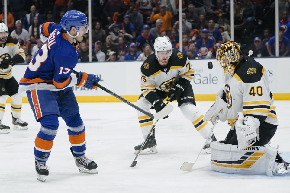 Boston Bruins goaltender Tuukka Rask (40) stops a shot on goal by New York Islanders' Mathew Barzal (13) as teammate Connor Clifton (75) watches during the overtime period of Game 3 during an NHL hockey second-round playoff series Thursday, June 3, 2021, in Uniondale, N.Y. The Bruins won 2-1. (AP Photo/Frank Franklin II)