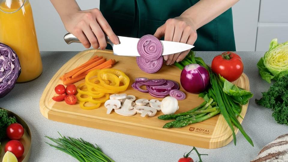 Model chopping vegetables on a cutting board. 